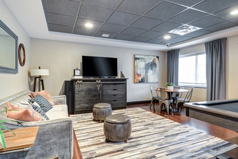 A living room with a pool table and a television.