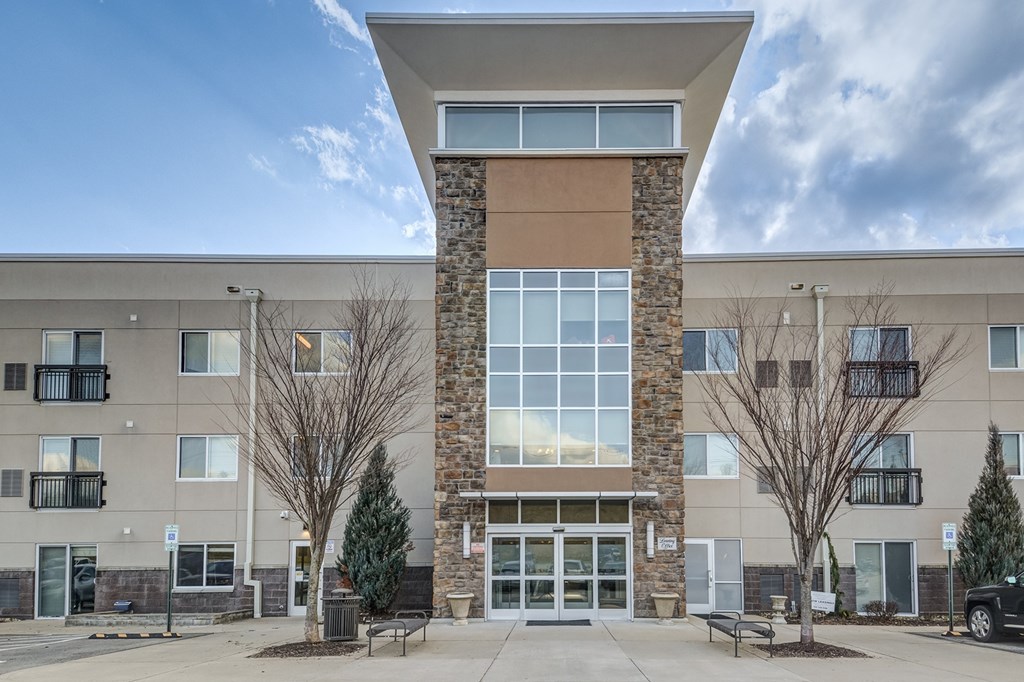 A modern building with a stone pillar in the center of the entrance.