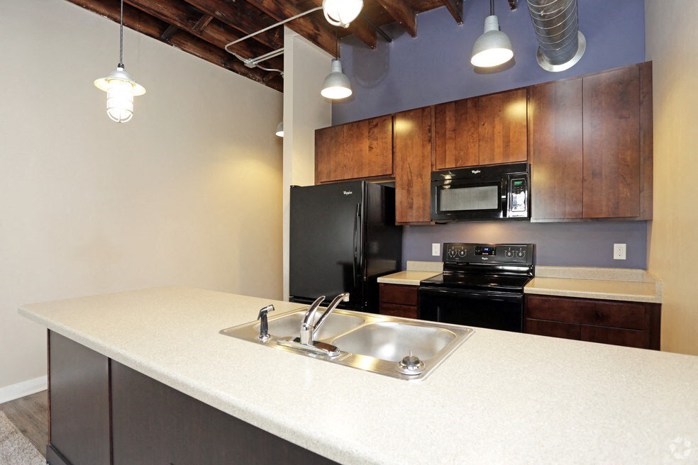 a kitchen with a sink and a black refrigerator