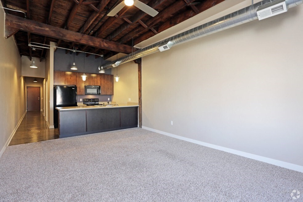 a room with a kitchen and a carpeted floor
