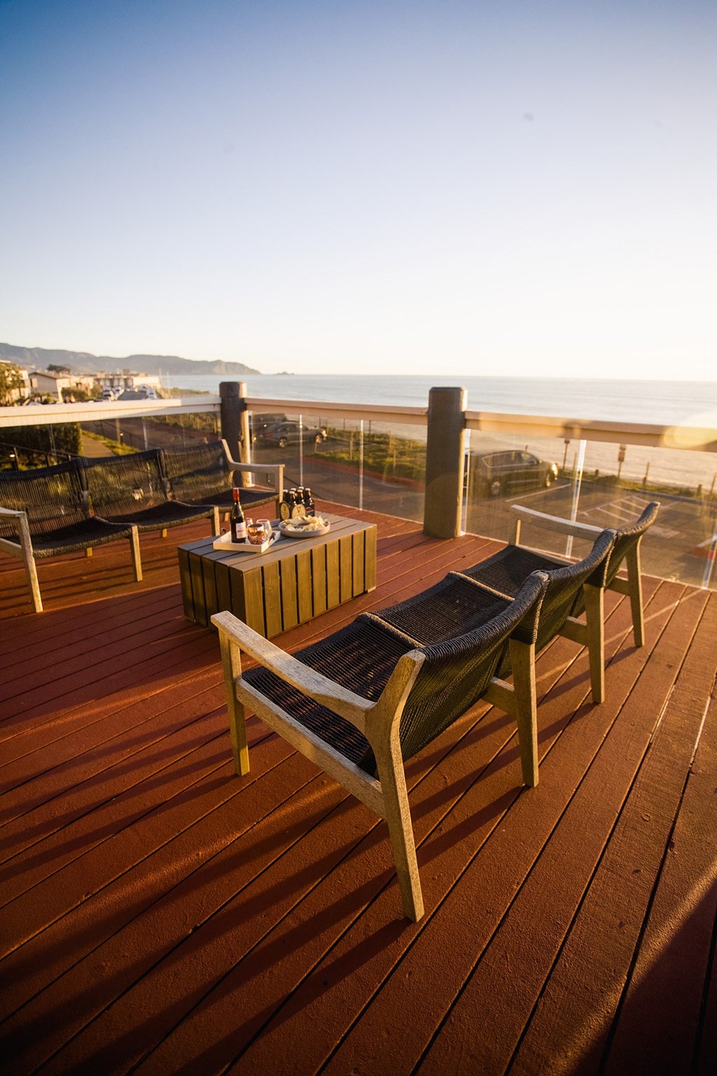 a deck with a table and chairs overlooking the ocean