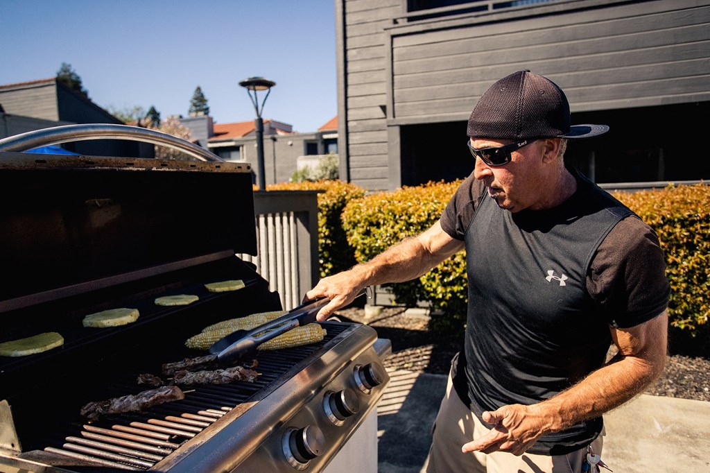 a man grilling food on a barbecue grill