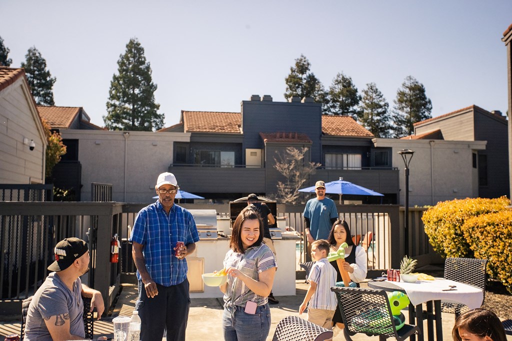 a group of people are gathered around a table on a patio