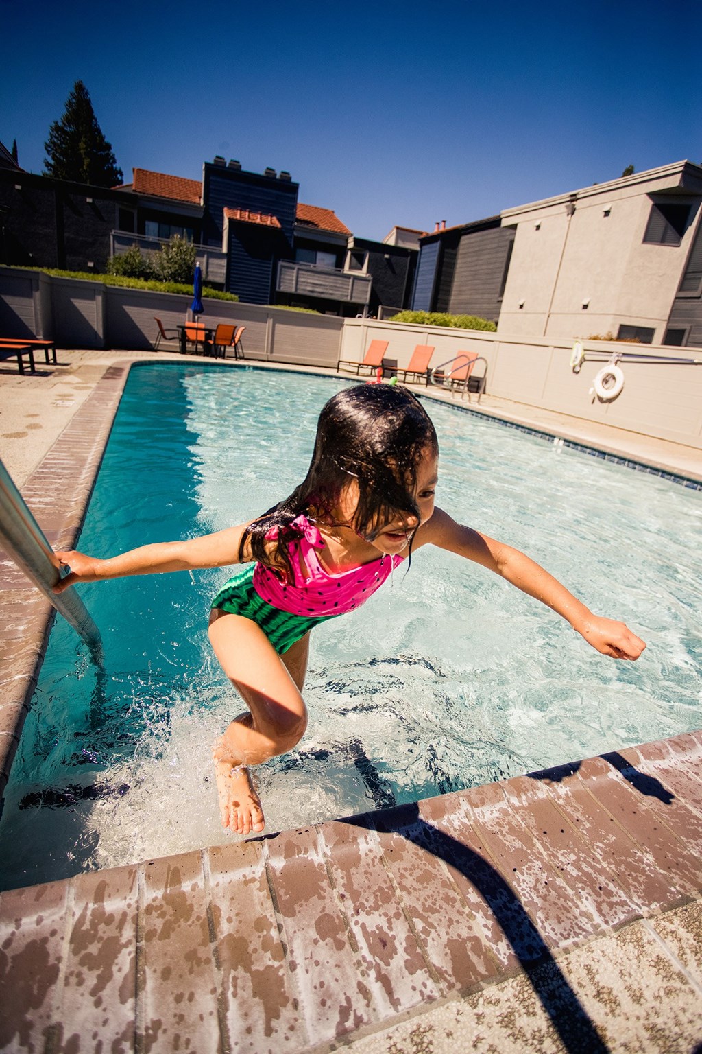 a little girl jumping into a swimming pool