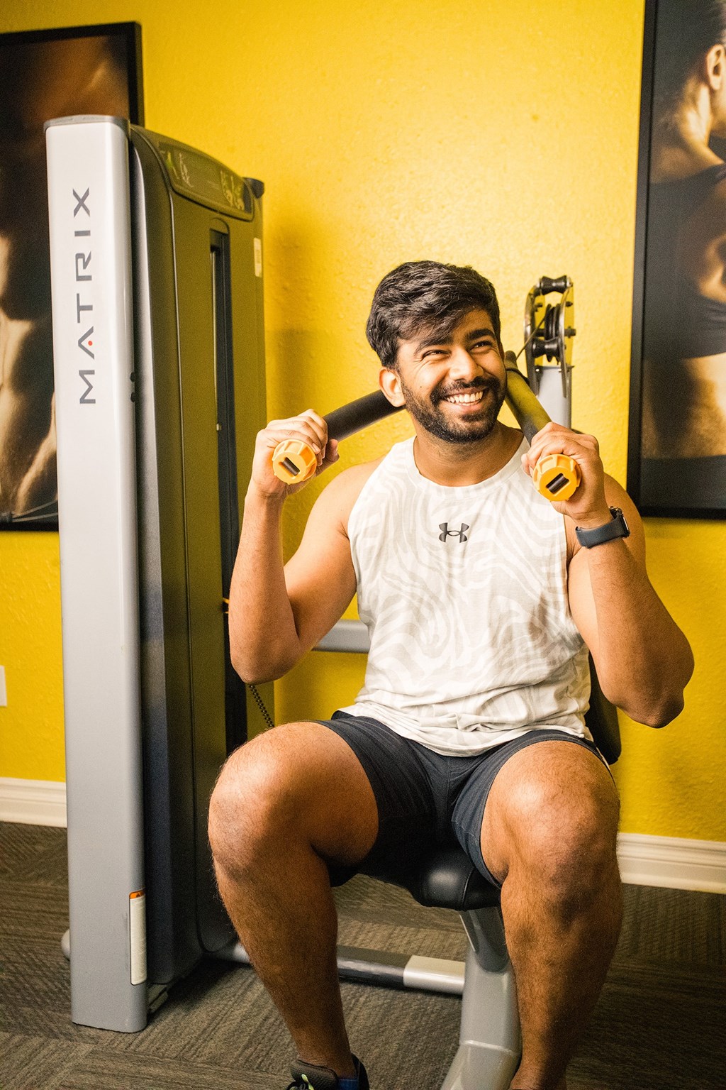 a man sitting on a gym bench holding a baseball bat