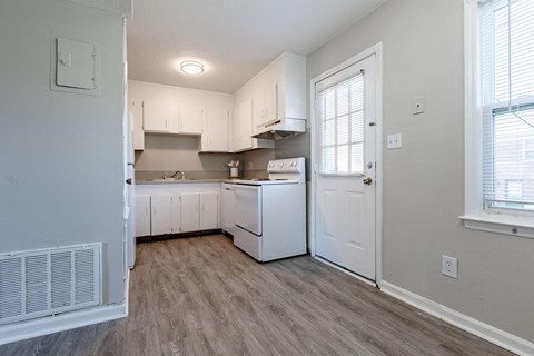 A kitchen with white appliances and cabinets.
