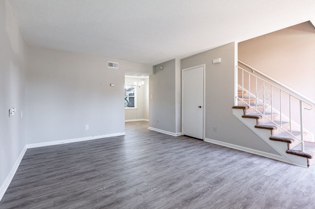 an empty living room with stairs and a door to a hallway at Sharon West, Charlotte North Carolina