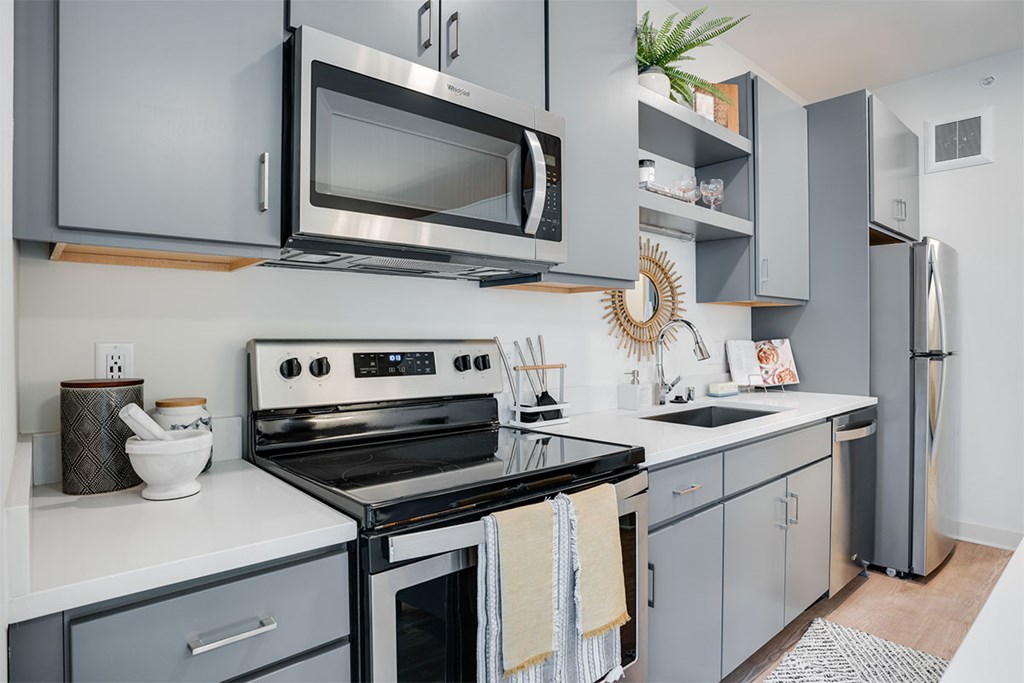 A modern kitchen with a stove, microwave, and refrigerator. at Sora Apartments, Minneapolis, MN, 55415