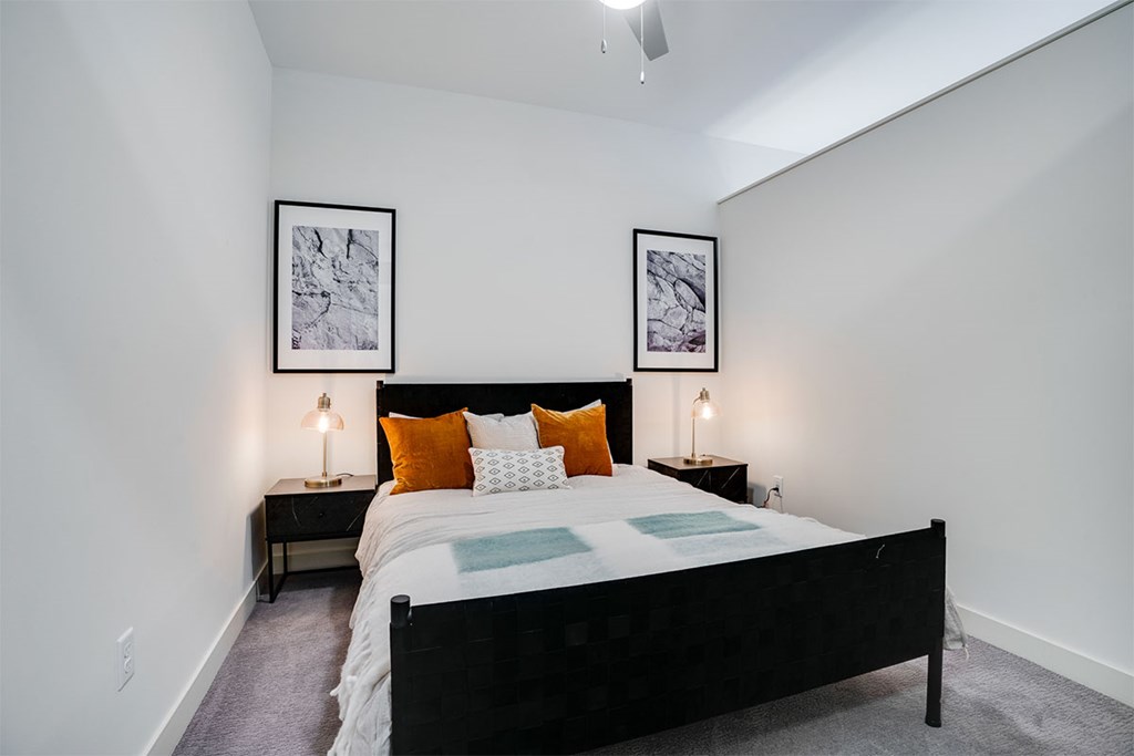 A bedroom with a large bed and two framed pictures on the wall at Sora Apartments, Minnesota, 55415