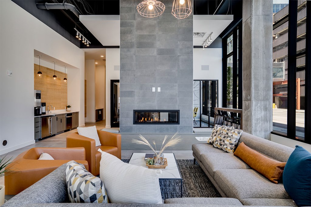 Lounge room with a fireplace and a grey sofa at Sora Apartments, Minneapolis, Minnesota