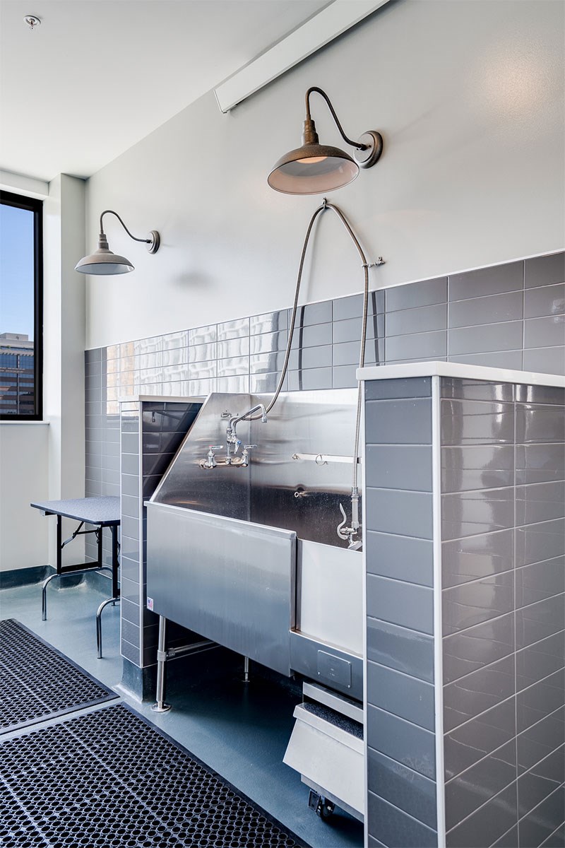 A modern kitchen with a stainless steel sink and a black and white tiled floor at Sora Apartments, Minneapolis, Minnesota