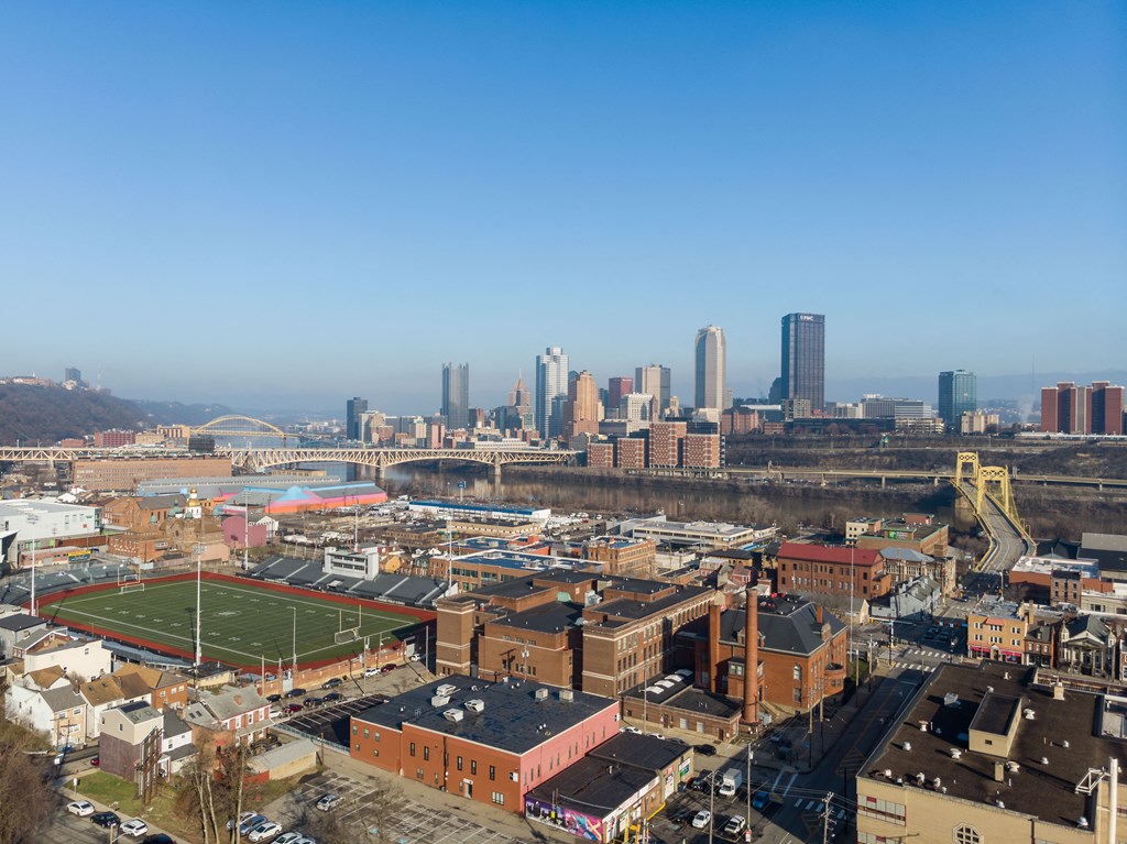 an aerial view of the city with a football field