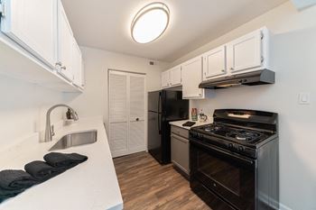 a kitchen with black appliances and white cabinets at The View Apartments St Charles, St Charles, IL, 60174