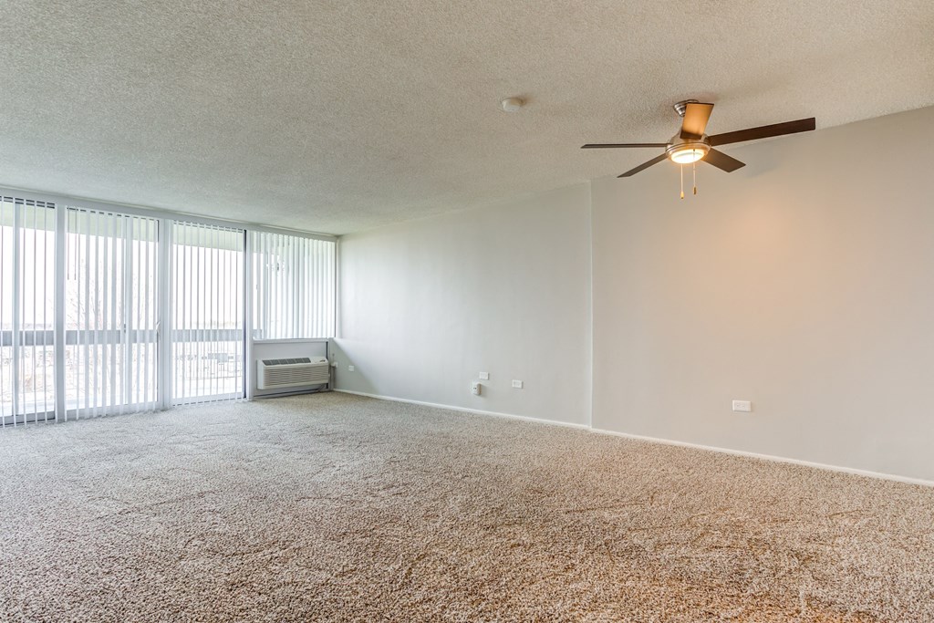 an empty living room with a ceiling fan at The Township at St. Charles, Illinois
