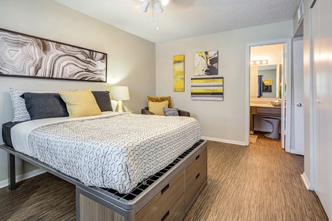 a bedroom with a bed and a bathroom with a sink at The Hub at Baton Rouge, Baton Rouge, LA 