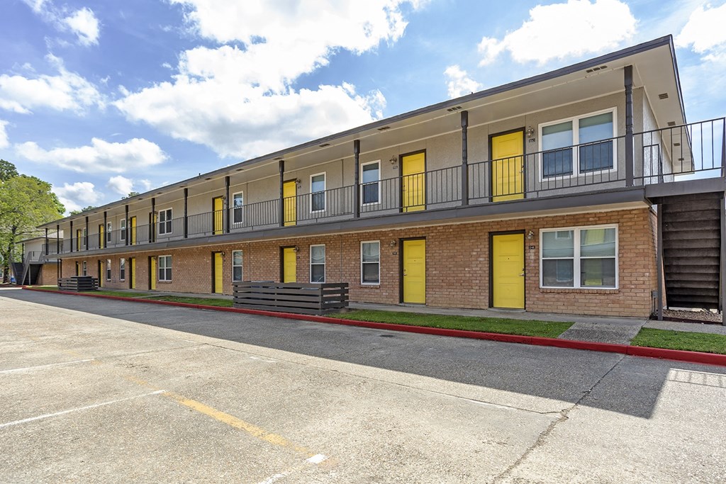 an exterior view of a brick apartment building with yellow doors at The Hub at Baton Rouge, Louisiana, 70808