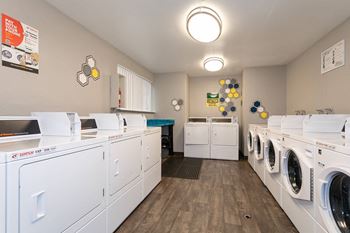 a washer and dryer room with white washes and dryers and laundry