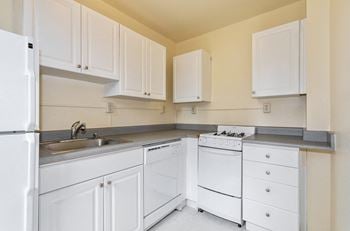 a kitchen with white appliances and white cabinets