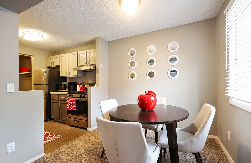 a dining room with a table and chairs and a kitchen