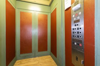 a row of elevators in a building with a wood floor