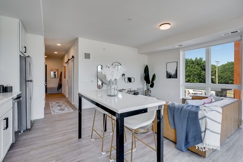 A kitchen with a white table and a white chair.