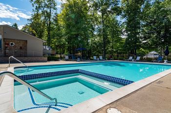 our apartments have a swimming pool and a patio with chairs  at Ascent at Farmington Hills, Michigan, 48331