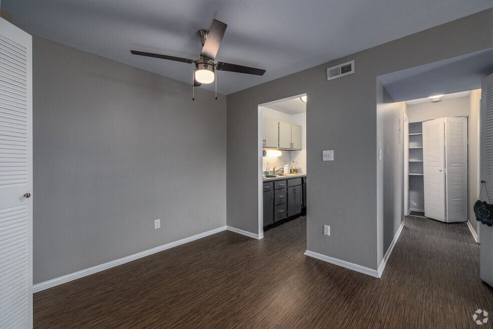 an empty living room with a ceiling fan and a kitchen  at The Avalon Apartment Homes, Missouri