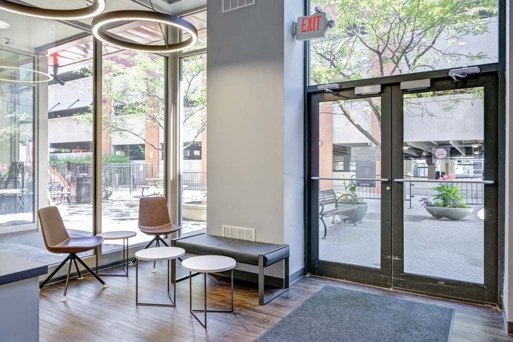 a room with a bench and chairs in front of a window at Flats at Southside, Pittsburgh, 15203