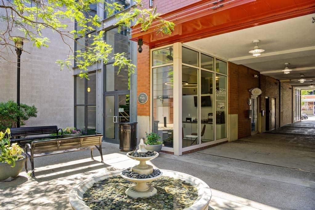 a courtyard with a fountain and a bench in front of a building at Flats at Southside, Pittsburgh, PA