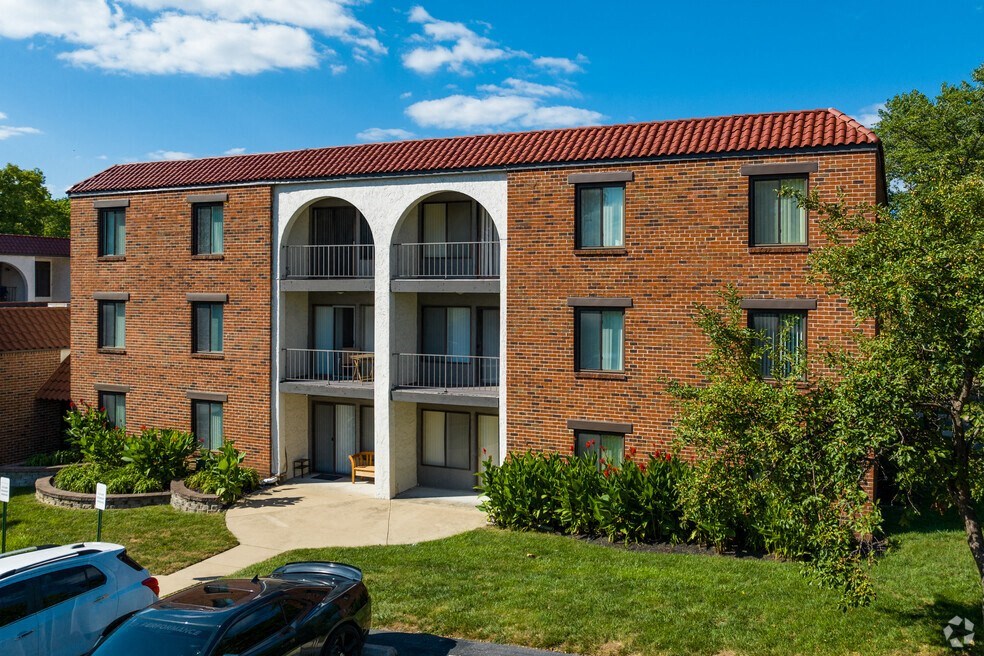 a brick apartment building with cars parked in front of it