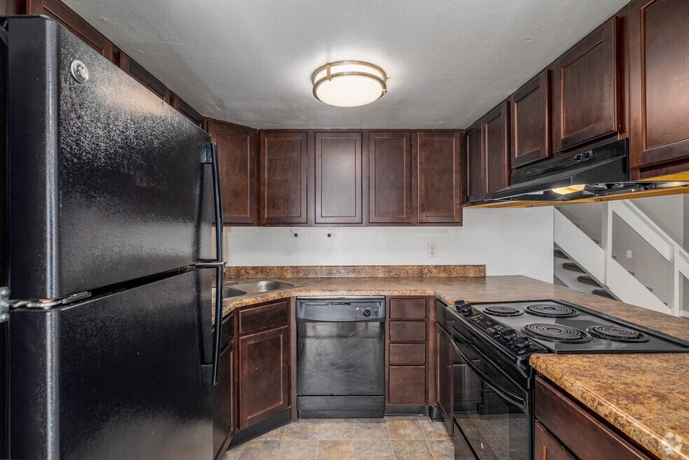 a kitchen with black appliances and wooden cabinets