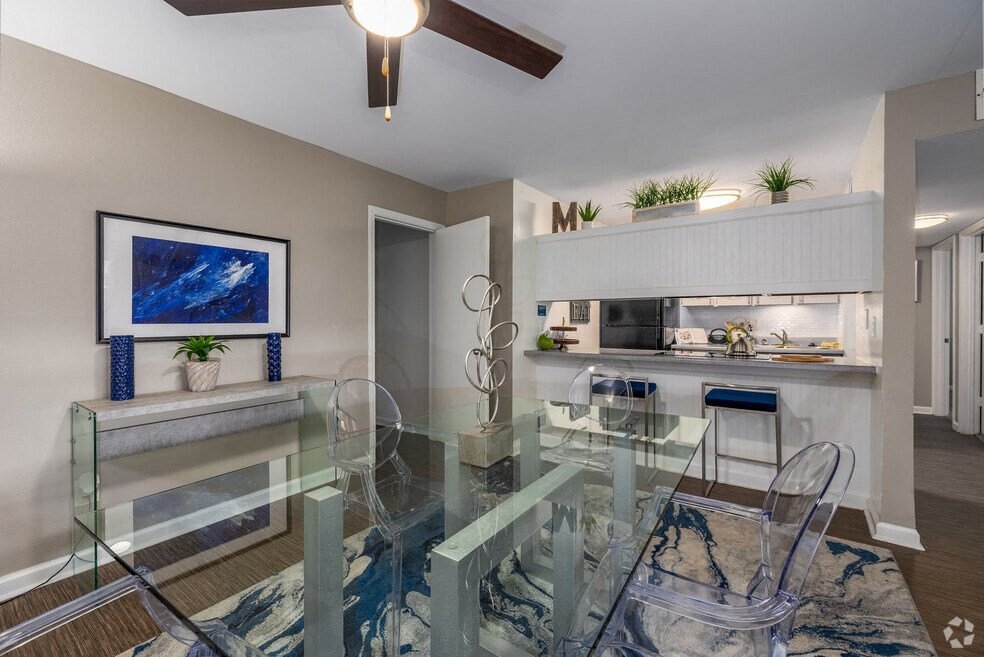 a dining room with a glass table and chairs