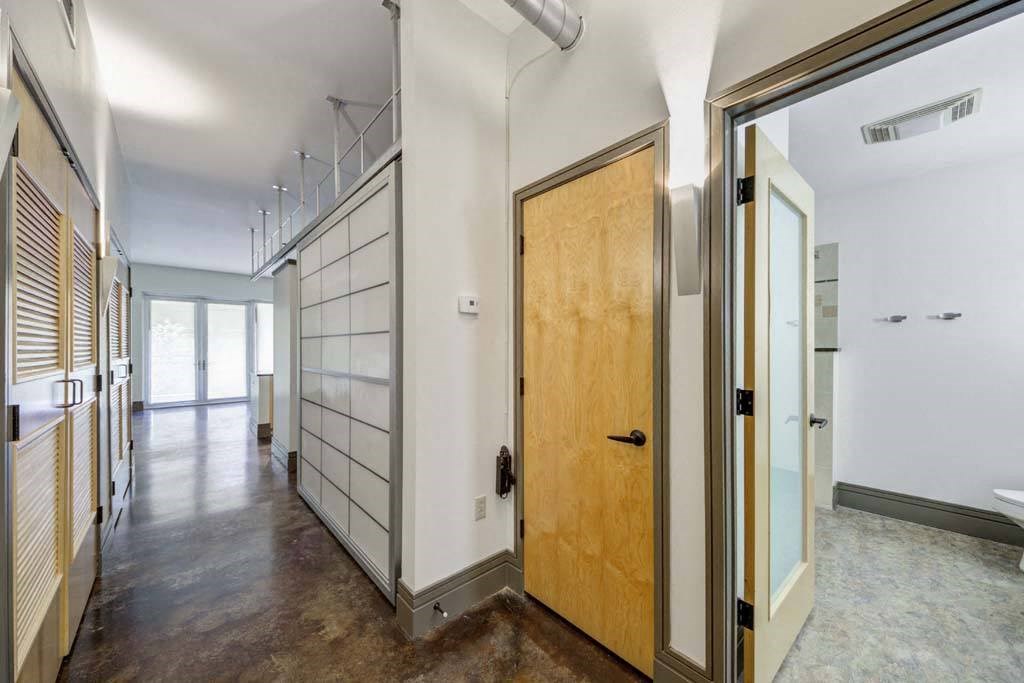 a hallway with a wooden door and white walls at Flats at Southside, Pittsburgh, 15203