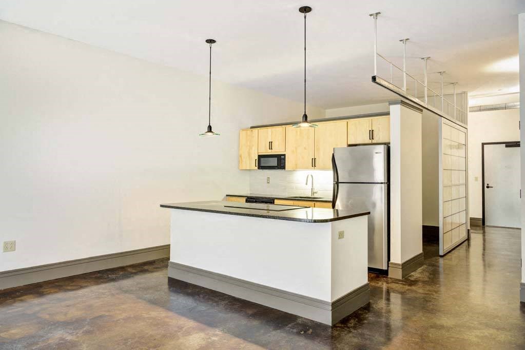 a kitchen with a counter top and a refrigerator at Flats at Southside, Pittsburgh, PA