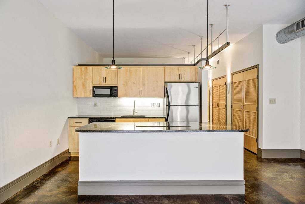 a kitchen with a counter top and a refrigerator at Flats at Southside, Pennsylvania