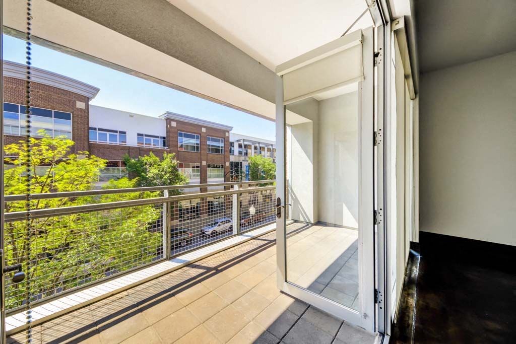 a large balcony with a sliding glass door and a view of a building at Flats at Southside, Pittsburgh Pennsylvania