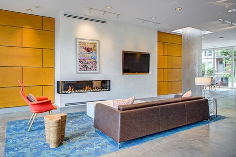 Living room with a fireplace, a couch, and a television at Track 29 Apartments, Minneapolis, MN, Minnesota, 55408