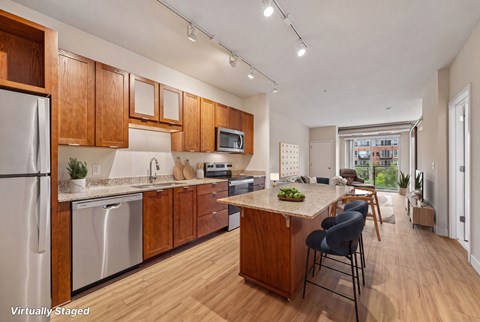 A kitchen with wooden cabinets and a stainless steel refrigerator.
