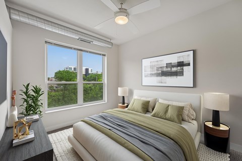 A bedroom with a large bed and a ceiling fan.