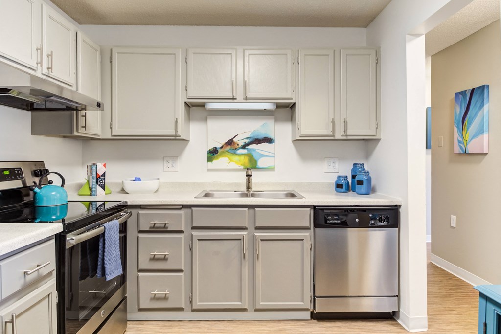 a kitchen with white cabinets and stainless steel appliances