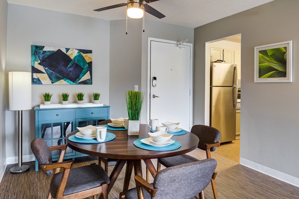 a dining room with a table and chairs and a ceiling fan