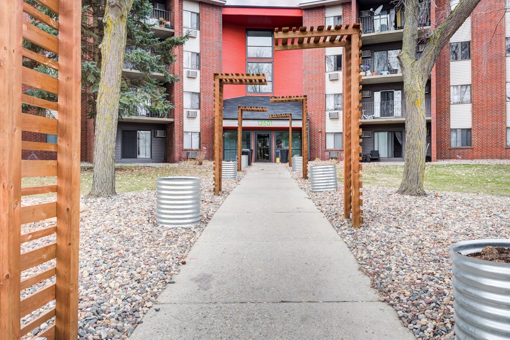 a walkway with a red brick building in the background