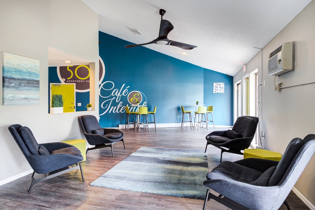 a lounge area with chairs and a rug