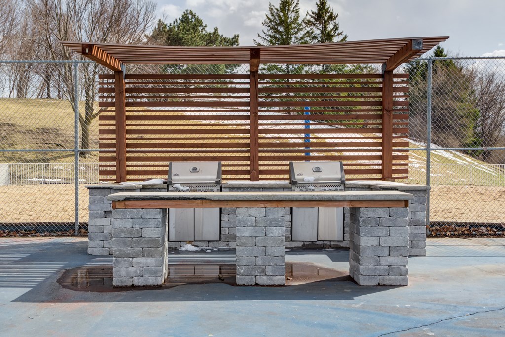 a stone barbecue grill with a wooden awning