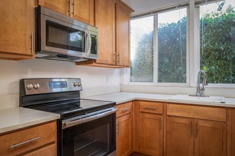 A kitchen with wooden cabinets and a black stove top oven.