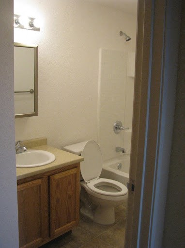 a bathroom with a toilet and a sink and a shower at Conifer Woods Apartments, Homer, AK, 99603
