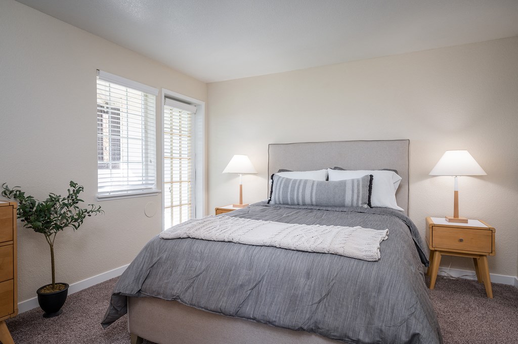 a bedroom with a bed and two lamps and a window at Sundial Apartments, Oregon