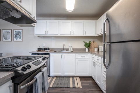 a kitchen with white cabinets and stainless steel appliances