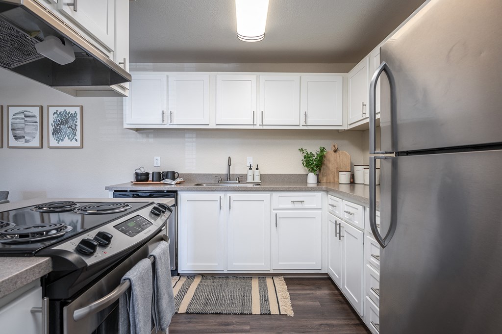 a kitchen with white cabinets and stainless steel appliances at Sundial Apartments, Oregon, 97070