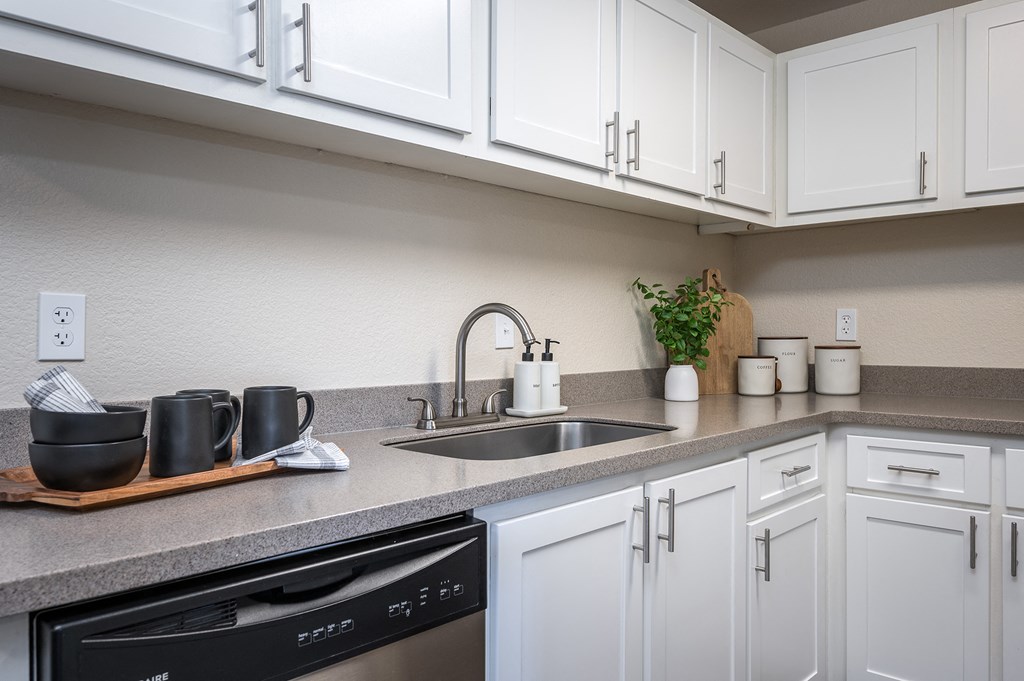 a kitchen with white cabinets and a sink at Sundial Apartments, Wilsonville, OR 97070